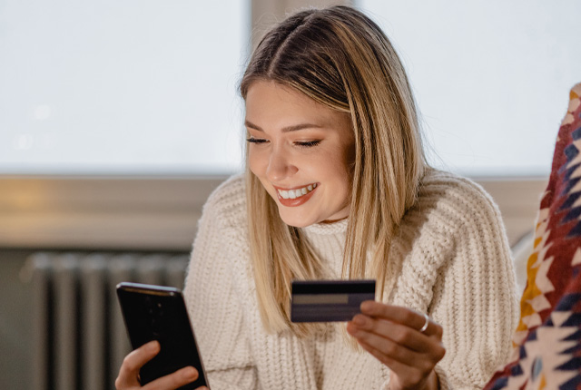 Uśmiechnięta kobieta, która robi zakupy na platformie marketplace, wiedząc, że nowe przepisy wprowadzone przez dyrektywę Omnibus chronią ją przed nieuczciwymi praktykami sprzedawców